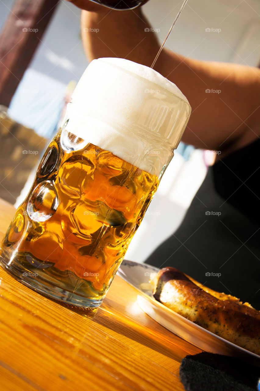 man pouring beer in big mug