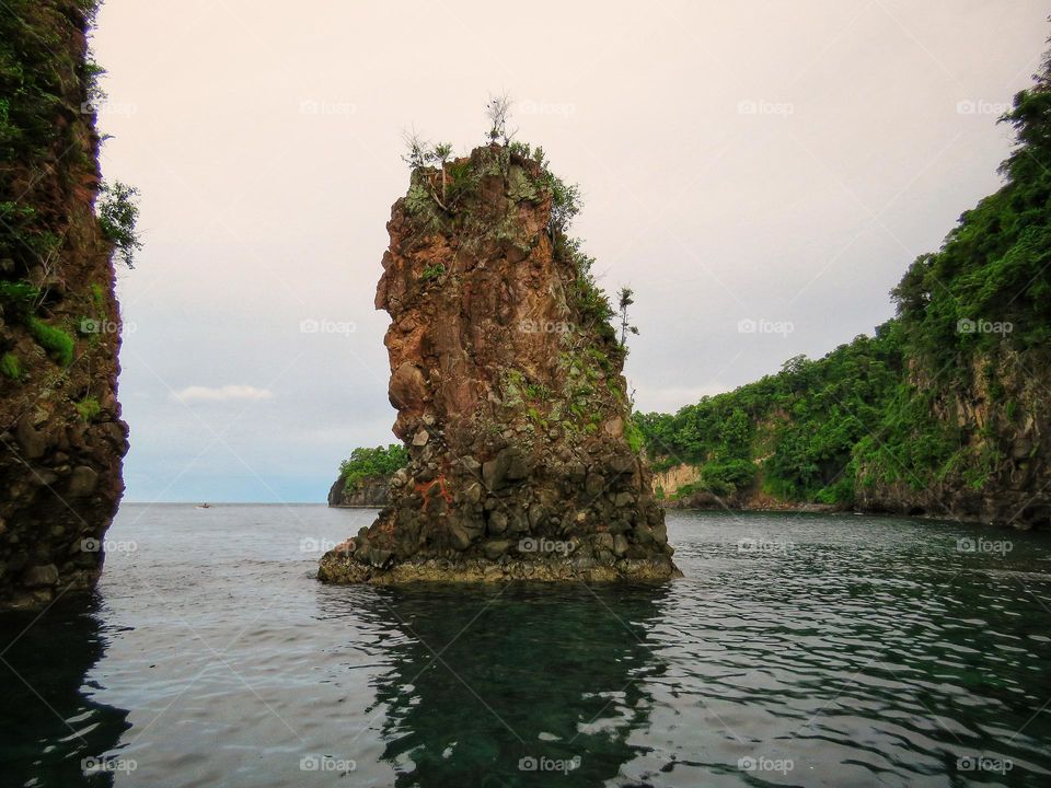 Nature landscape, a small rock island between two big islands.