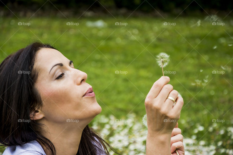 woman blowing dandelion