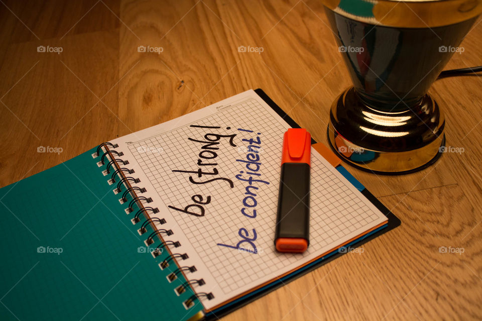 Motivational letter in a notebook on the desktop under the light of a lamp