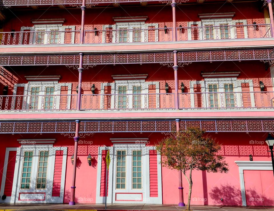 A vibrant pink hotel stands out against the normal muted colors of most buildings