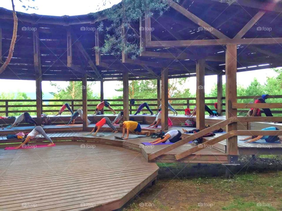занятие по хатха йоге на улице в деревянной беседке