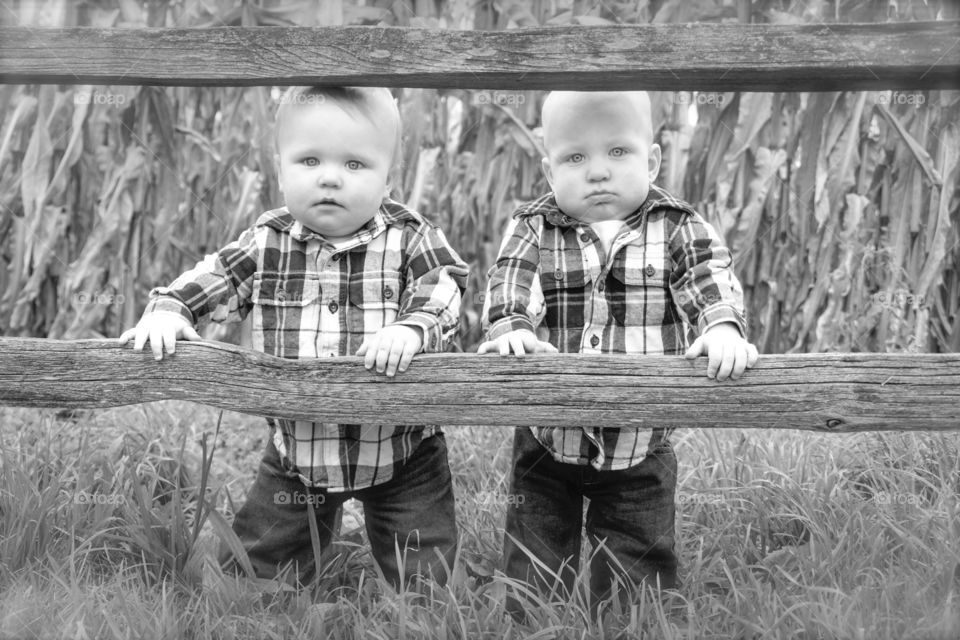 Cute twin boy standing on grass