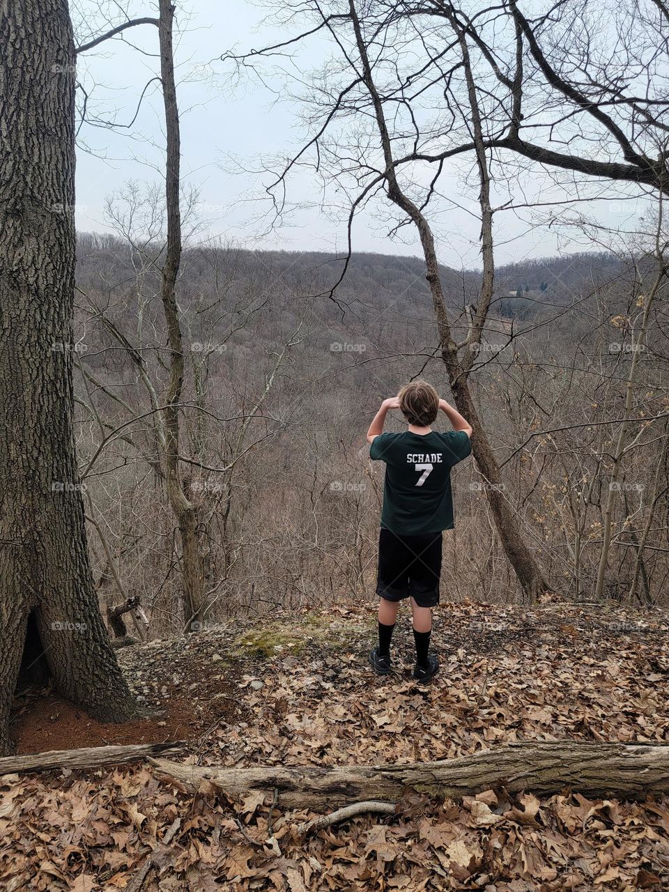 Teenager enjoying view on mountaintop while hiking