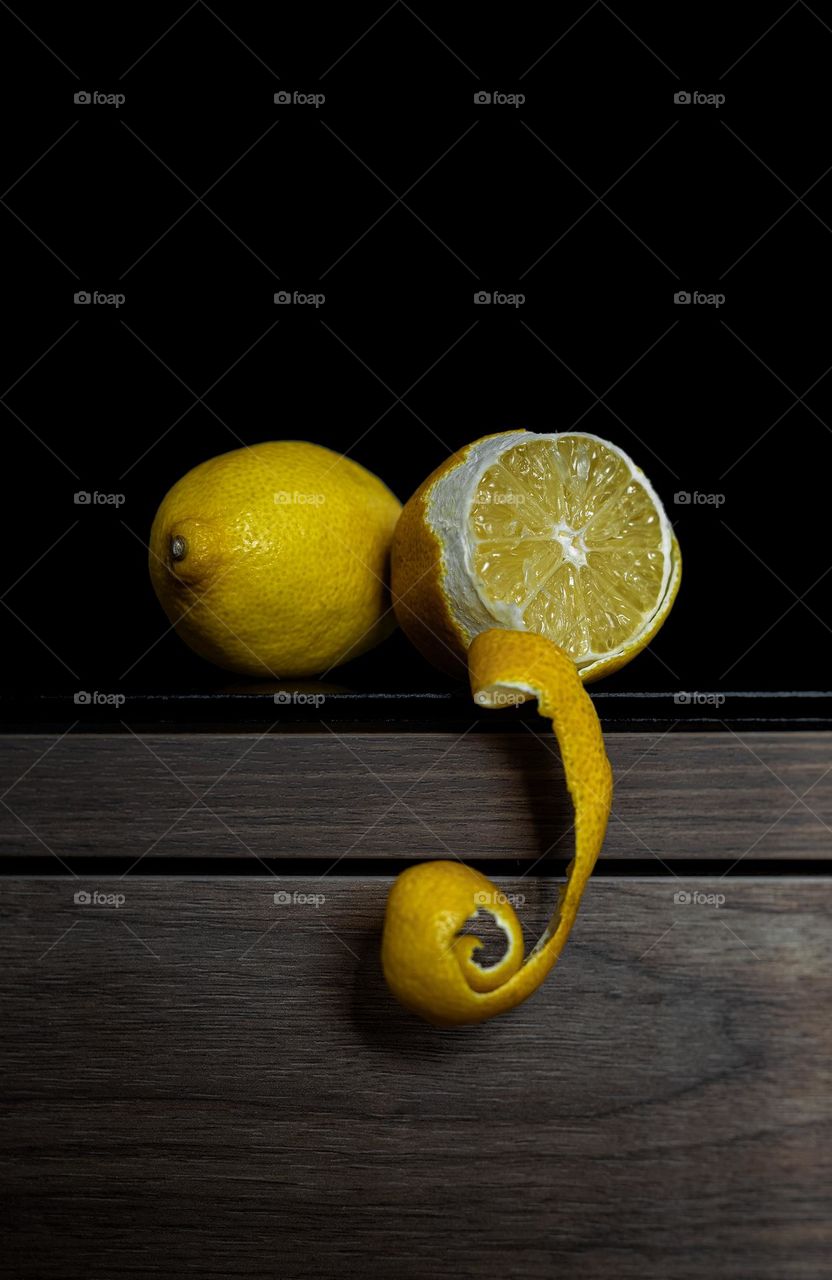 Close-up of peeled lemon on table against black background.