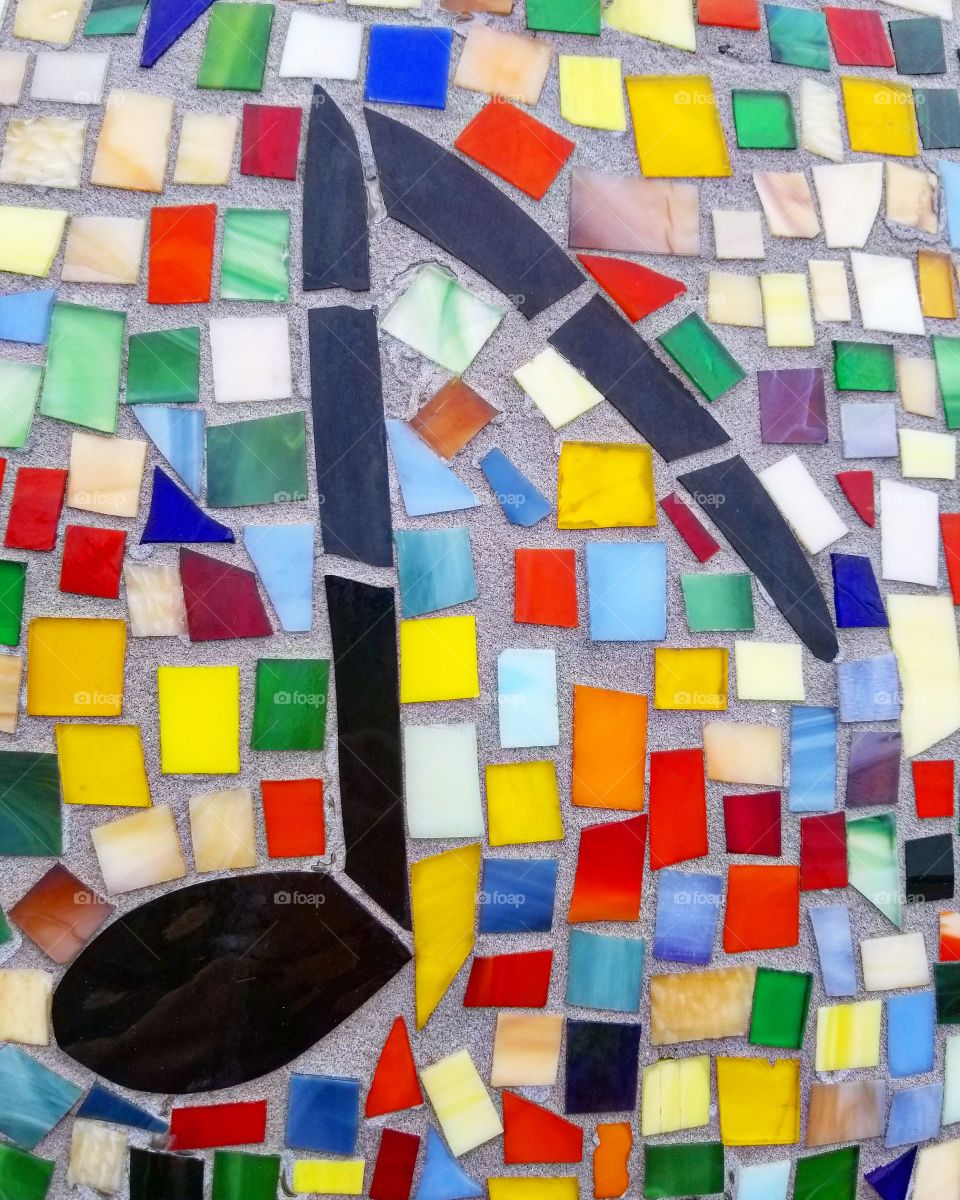 Colorful rainbow mosaic music note art set in stone