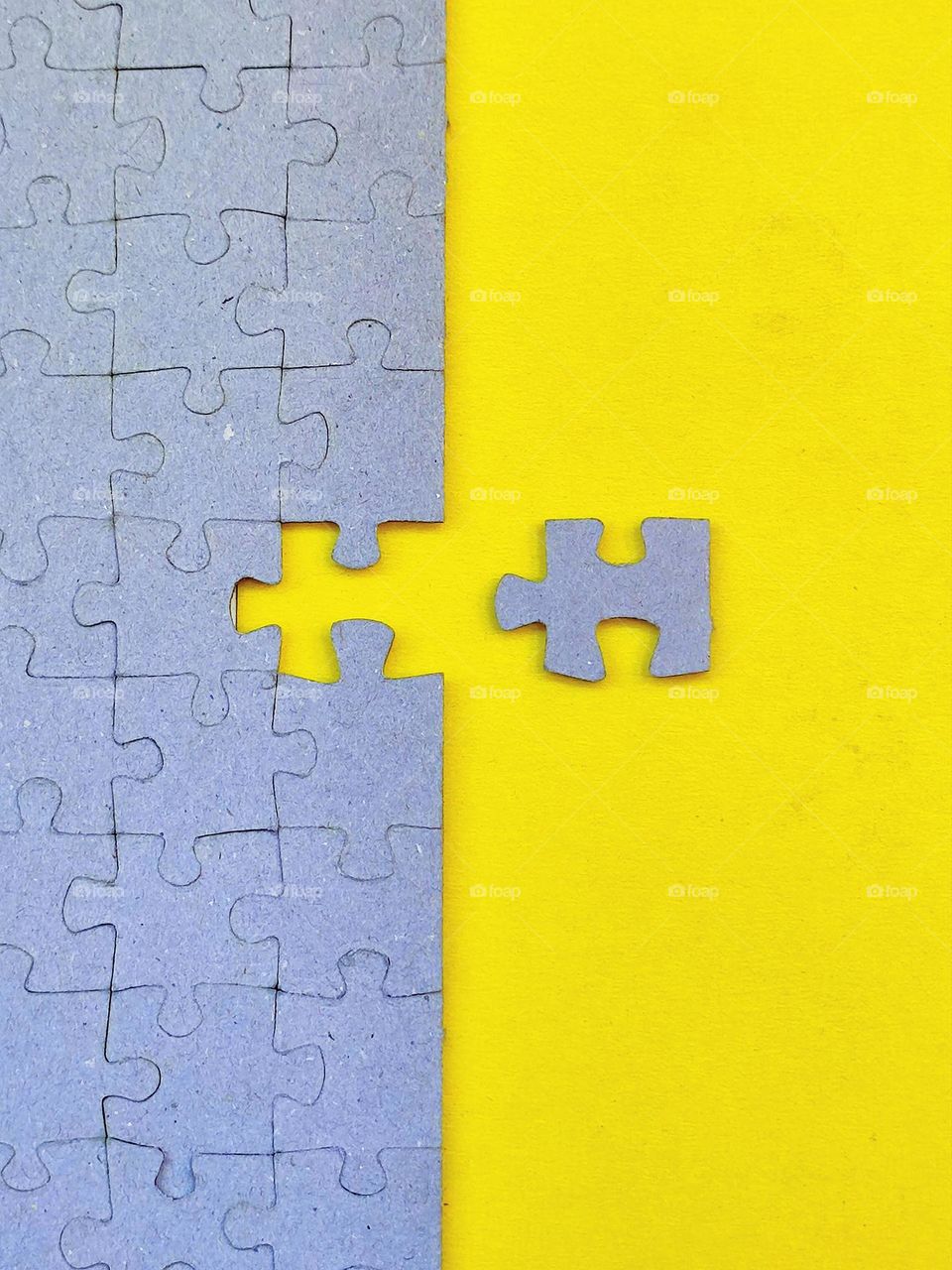 Yellow. Contrast of gray puzzles and yellow smooth base. For effective contrast, one gray puzzle lies on a yellow surface.