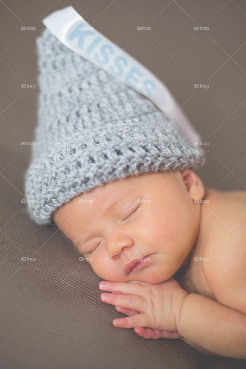 Gray woolen conical hat on sleeping baby's head