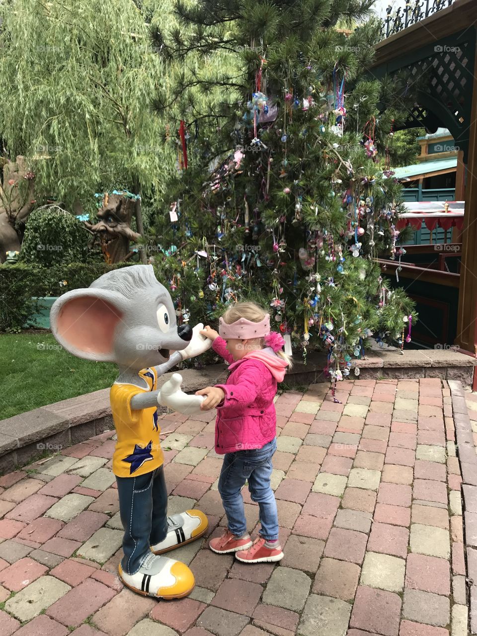 girl dancing with a mouse, girl in a pink jacket, Europe Park Germany, tree with nipples