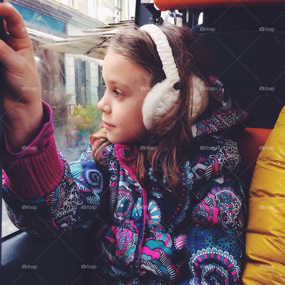 Young girl looking through window in public transport