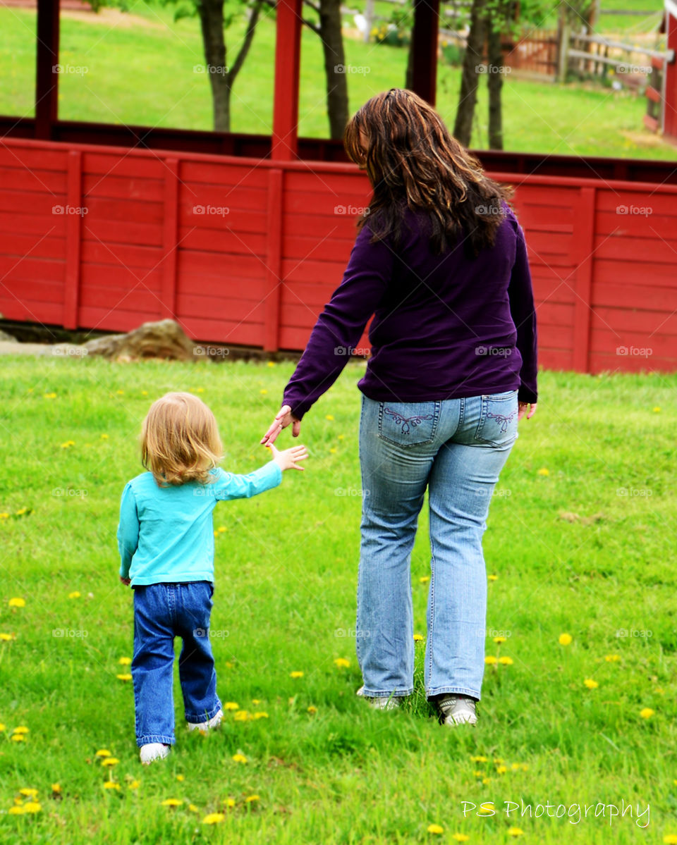 hold my hand mama. mother and daughter in park