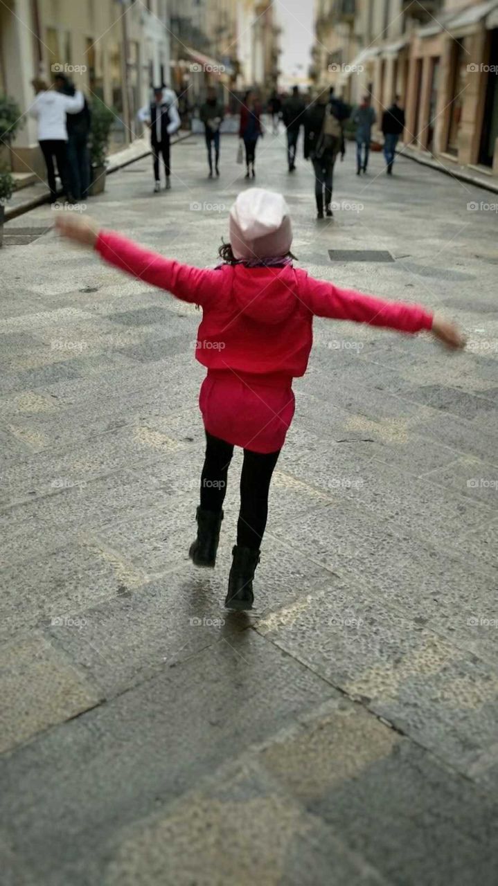 little girl waving her arms in the street