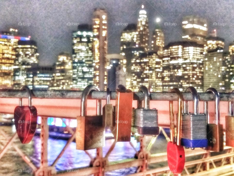 lovelocks on Brooklyn bridge with background nighttime cityscape, New York city