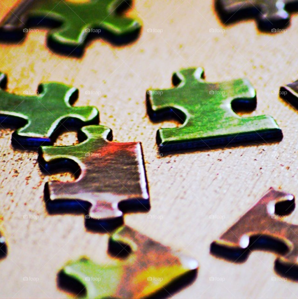 Close-up of an unfinished puzzle on a wooden table.