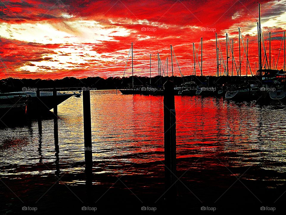 
Silent sailboats rest in the mariner after a day of sailing in the Gulf of Mexico. The sun was sinking fast now; the sky had turned to a clear, purple-tinged grey, but to the west there was a ruby-red glow.