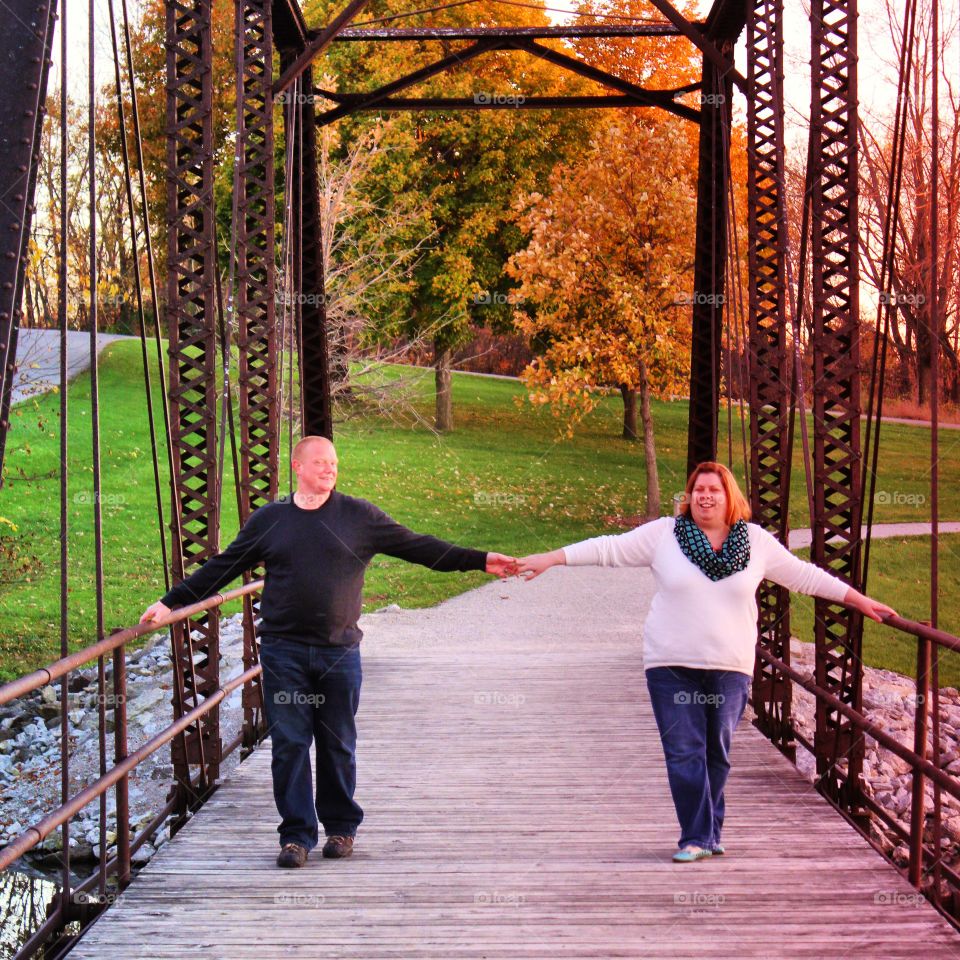 Happy mature couple holding hands on bridge