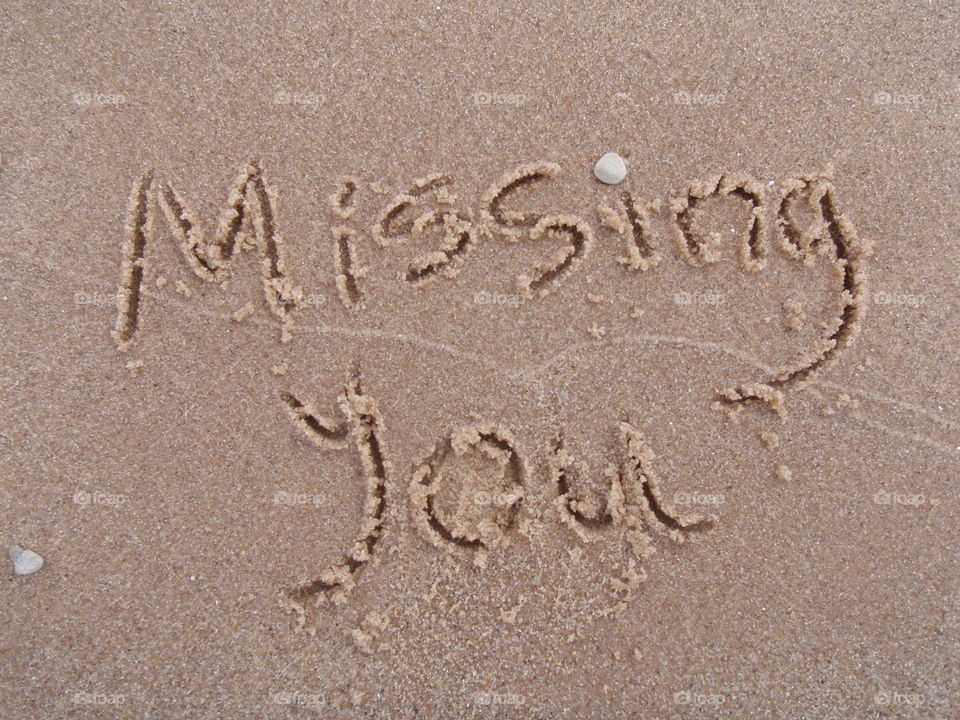 Missing You message in sand. Missing You message in sand