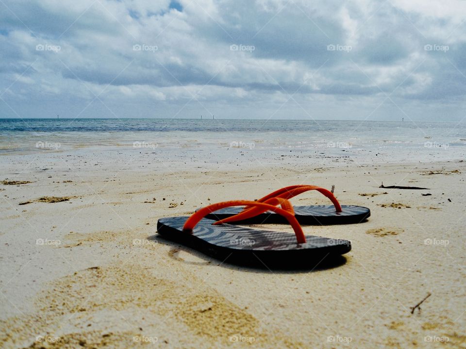Flip flops on a sandy beach 