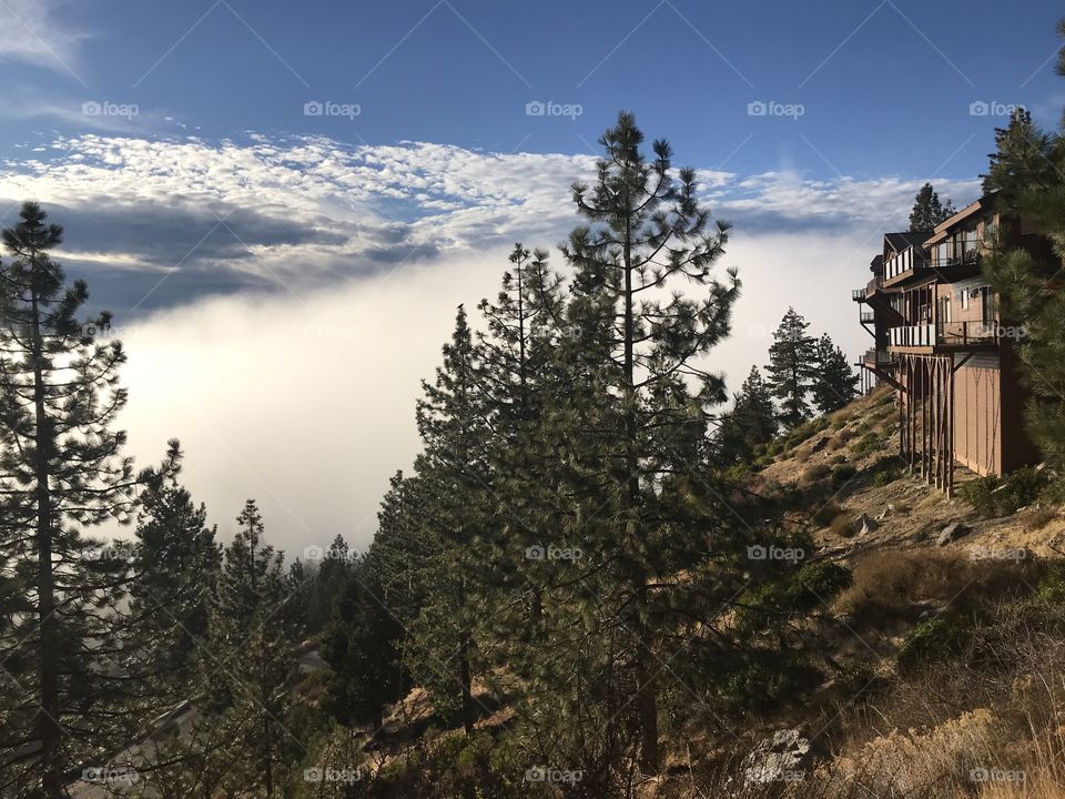 A house that overlooks the lake no longer with a view as clouds and fog move into the mountains. 