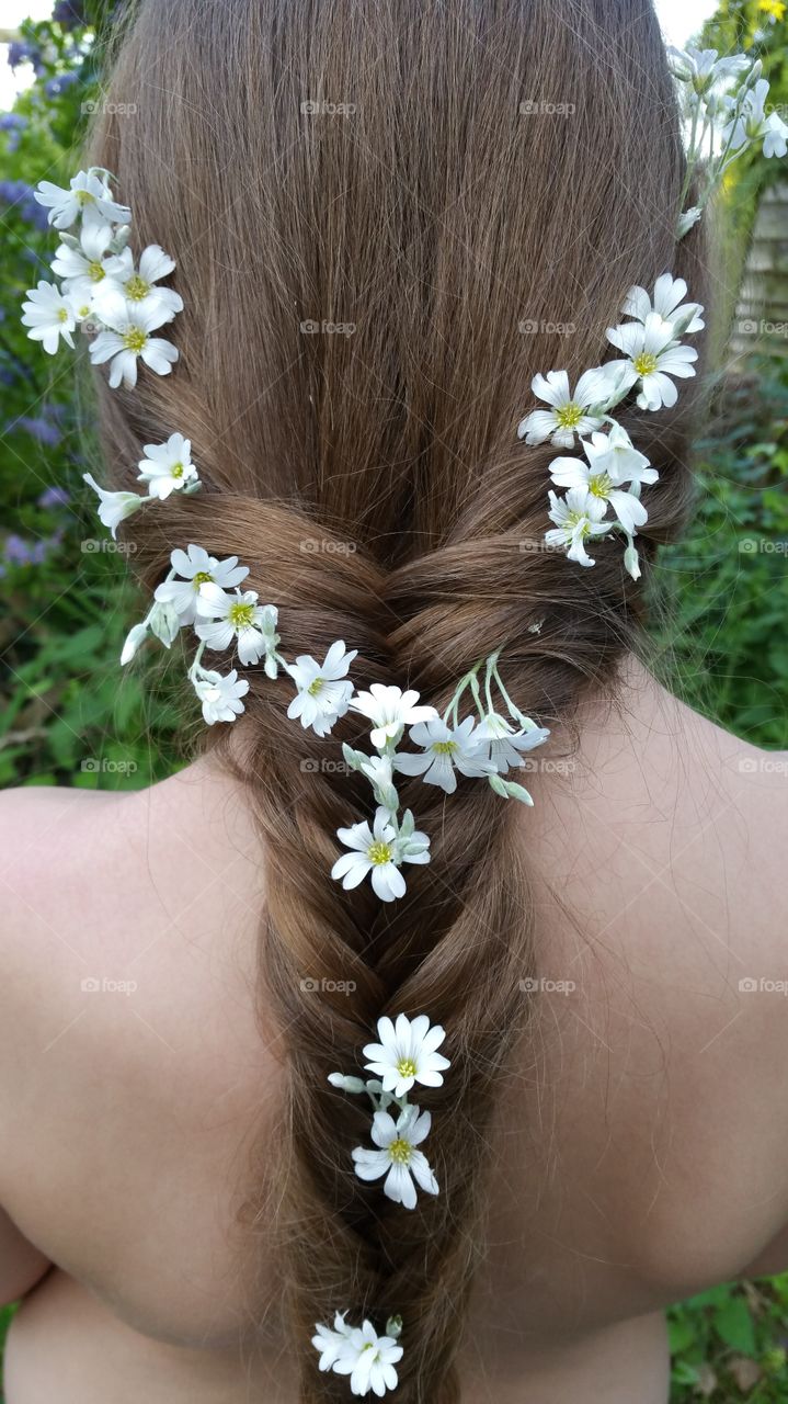 white flowers sitting in a brown haired long fish tail braid