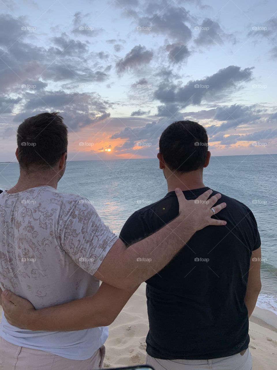 Man hugging looking sunset 