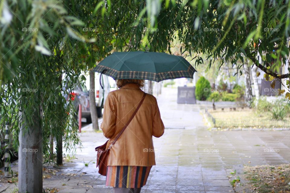 Raining day, street, a woman holding an umbrella
