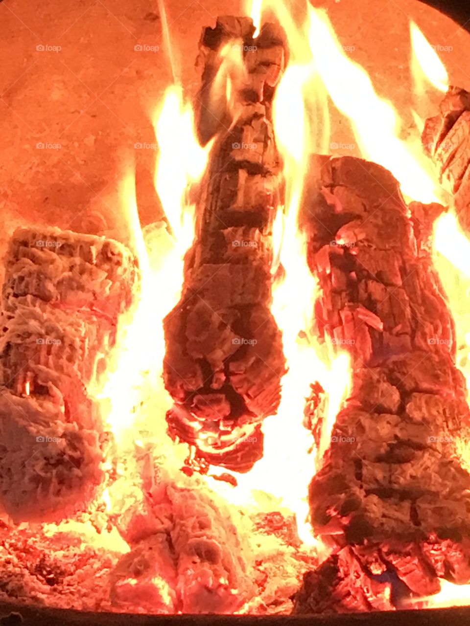 Close up view of logs burning in the chiminea fire with flames
