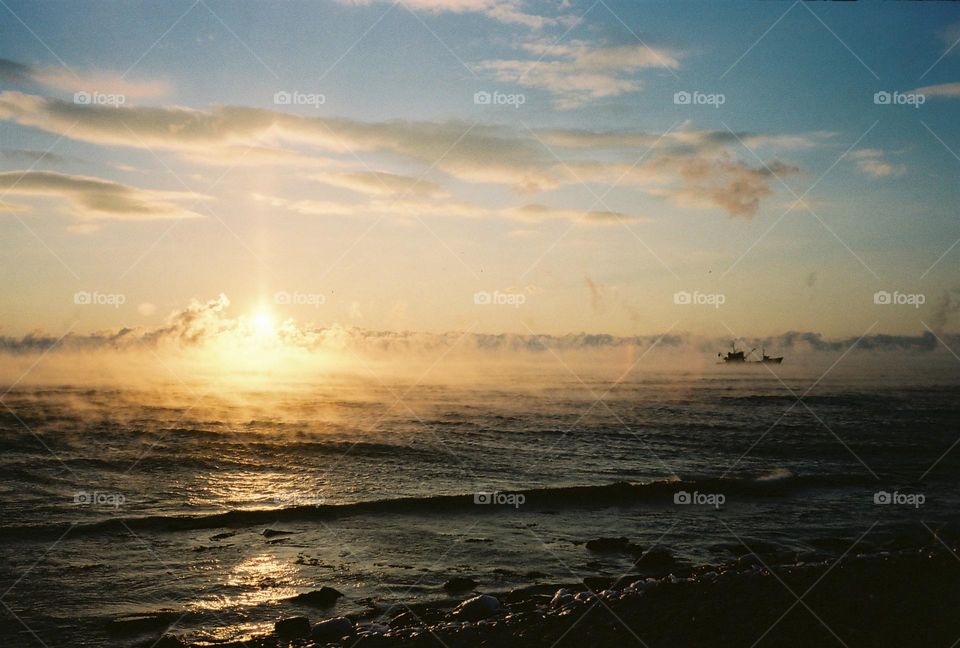 Cold winter sea, frozen windy seaside in a sunset