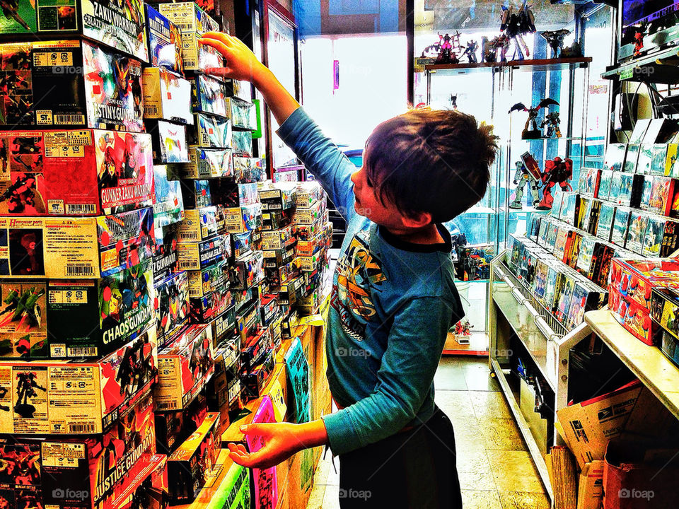 Young boy reaching for a toy in a large store display