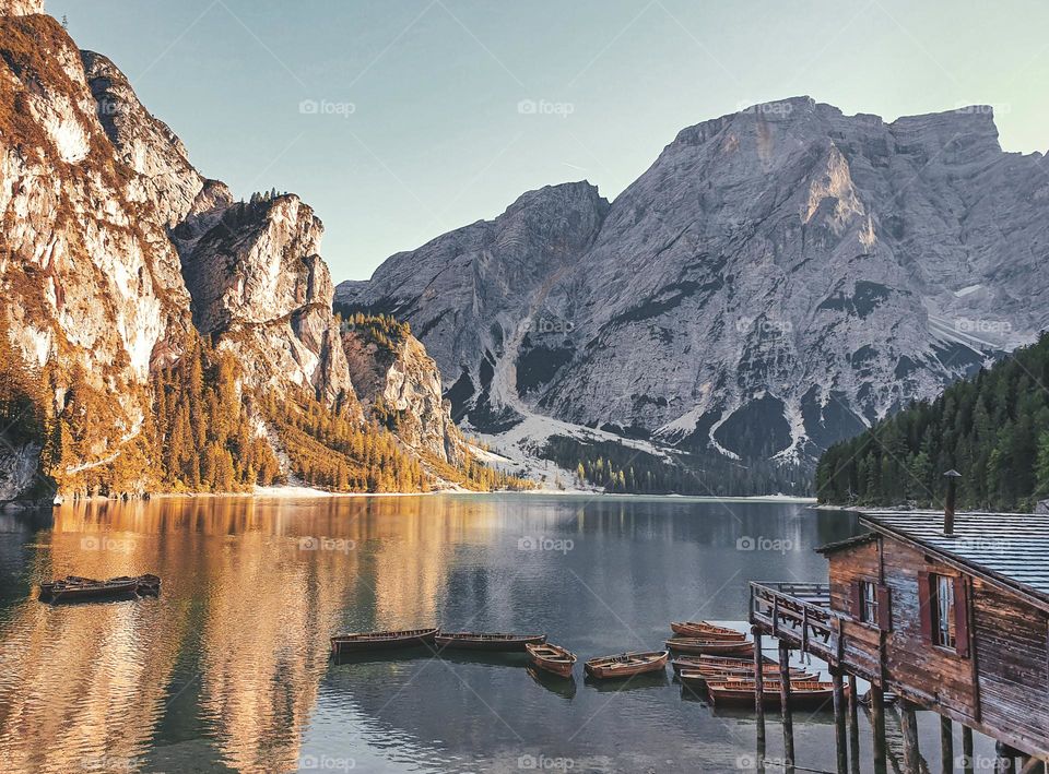 Amazing autumn scenery with wooden boathoude at a lake in mountains at Lake Braies in Italy