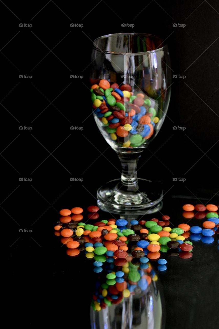  Colorful M&Ms in a wine glass with M&Ms below the glass