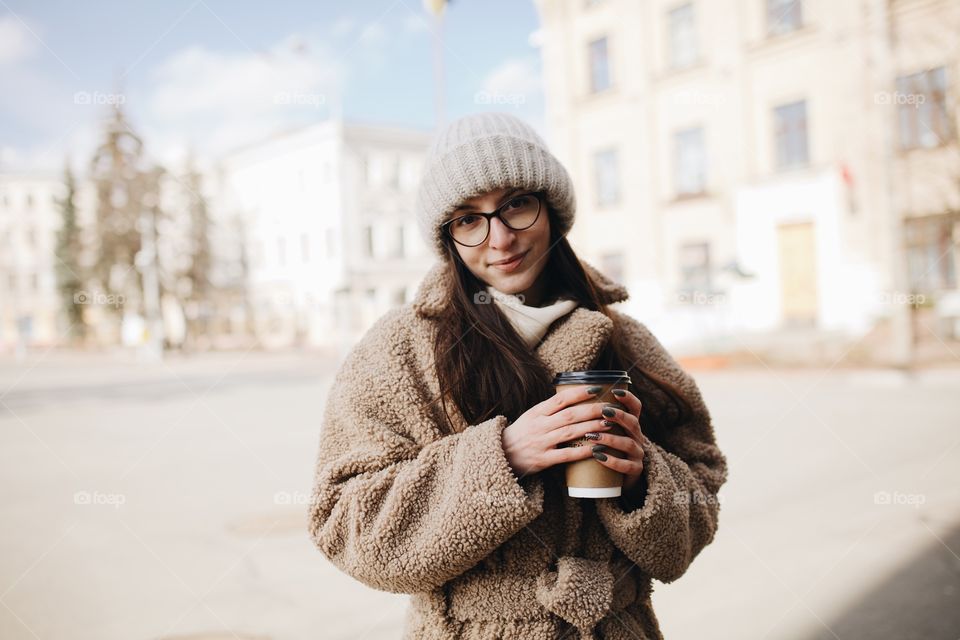 young woman drinking takeaway coffee in the city center