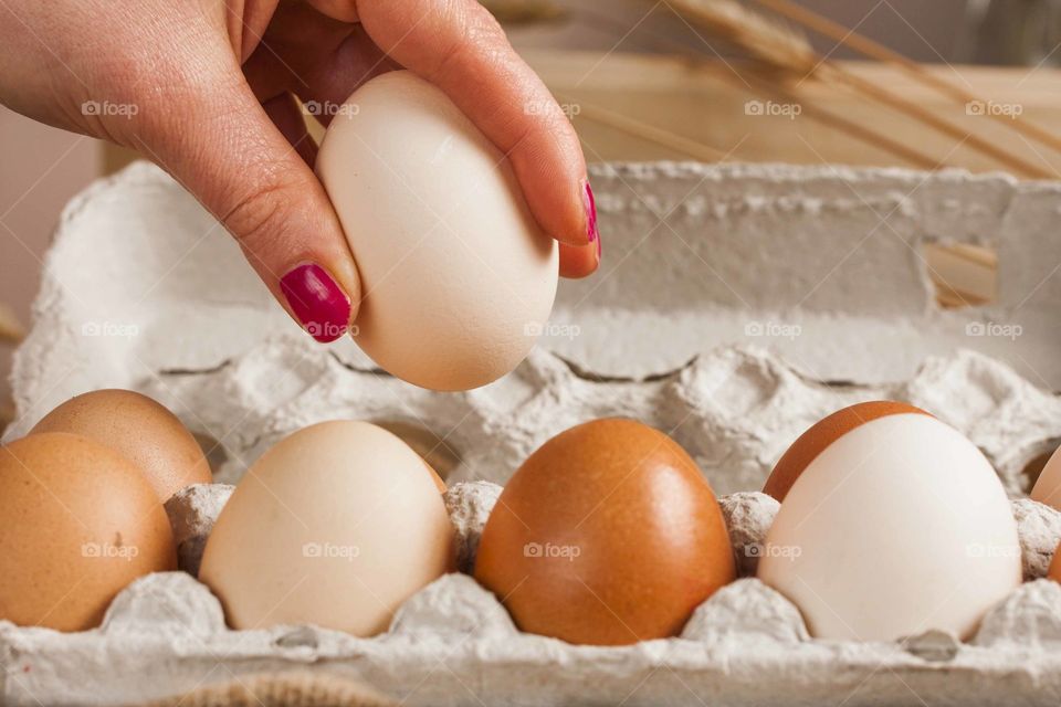 Close up of woman taking an egg out of the egg carton