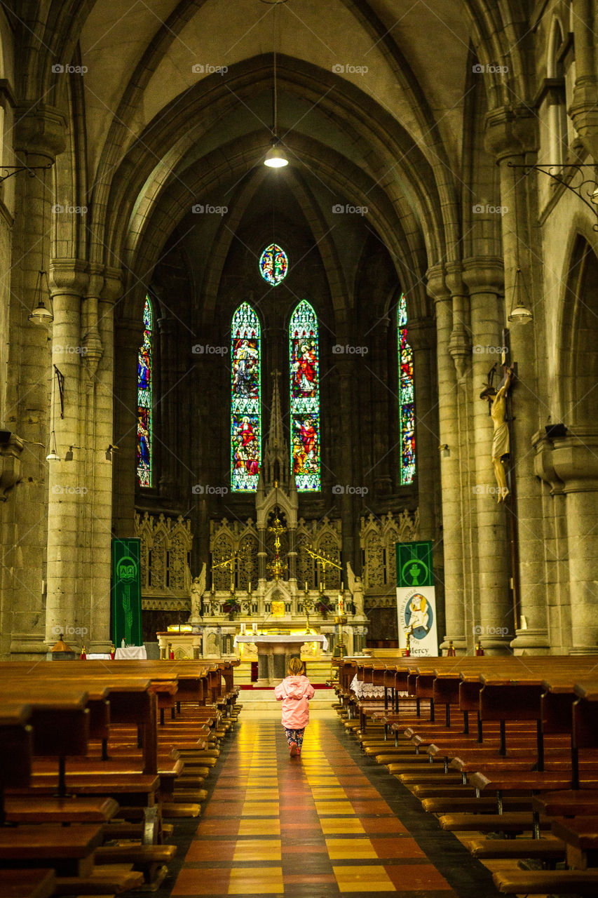 Love this moment - the bigness of the church in contrast to my little girl walking down the middle. Image of girl walking in cathedral with rain coat and boots.