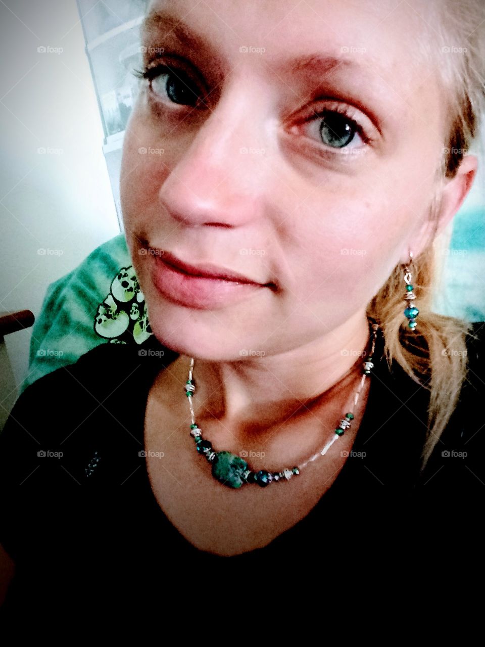 young woman without any makeup trying on new jewelry