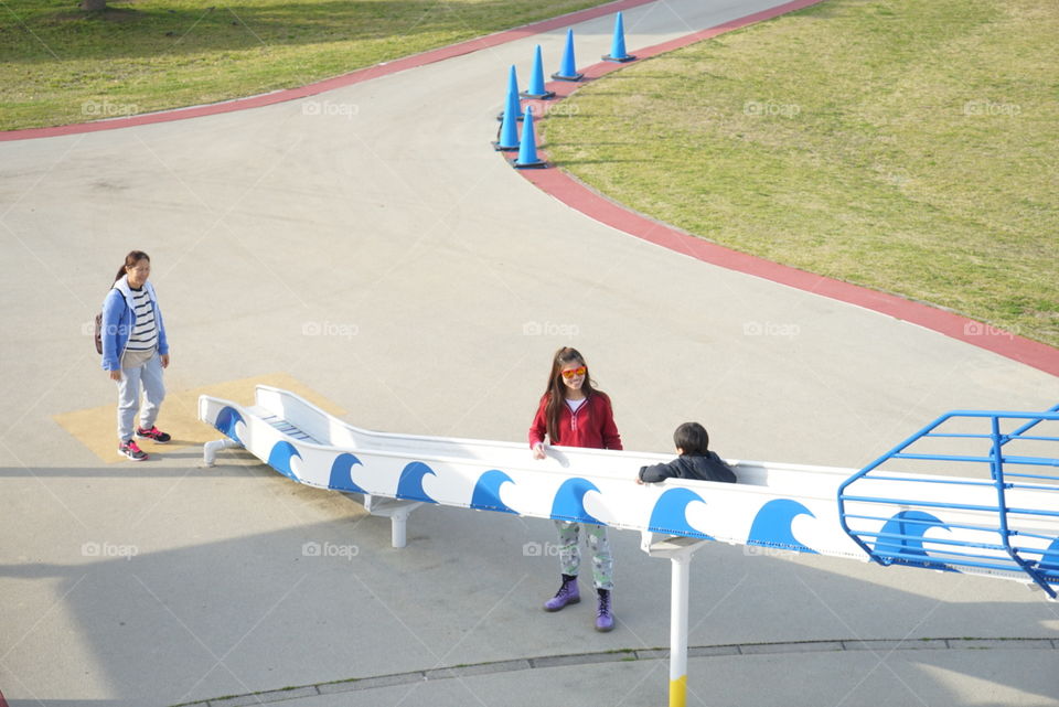 Japanese family watching a boy on playground slide