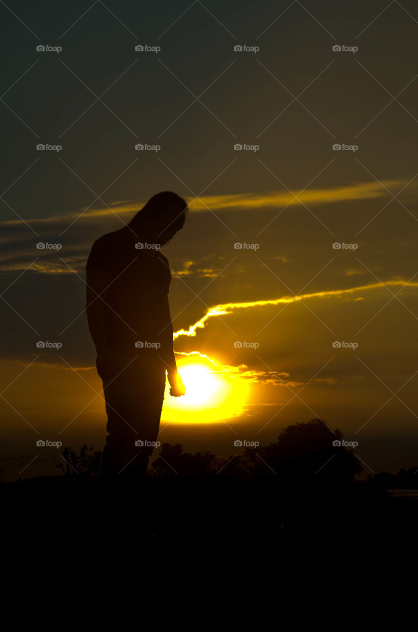Silhouette of person standing at sunset