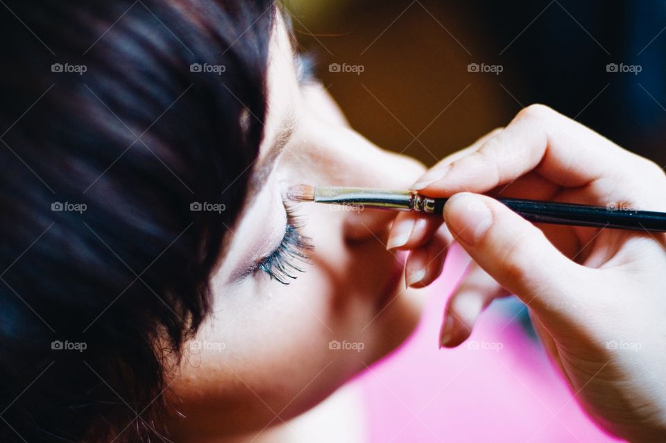 Artist applying eyeshadow on woman's eye