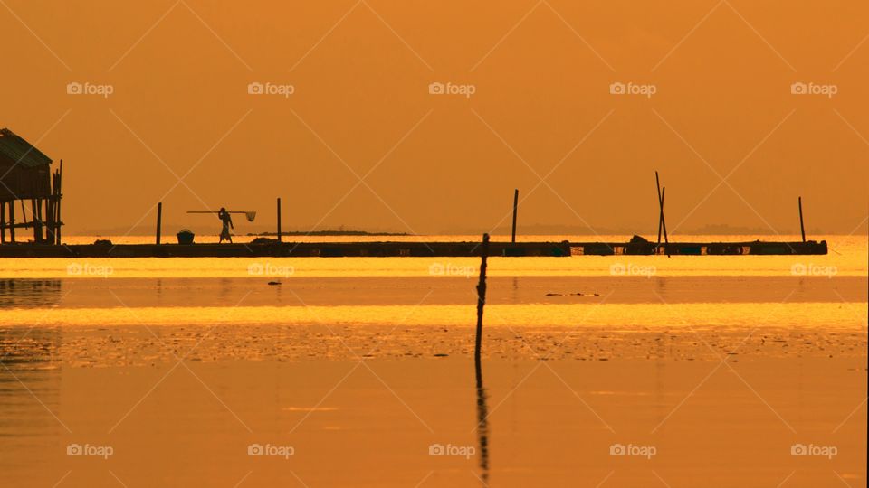Golden hour silhouette man at the beach before sunset