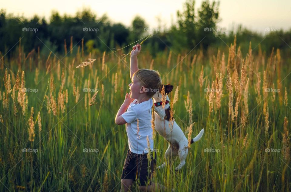 The boy is playing with his dog.