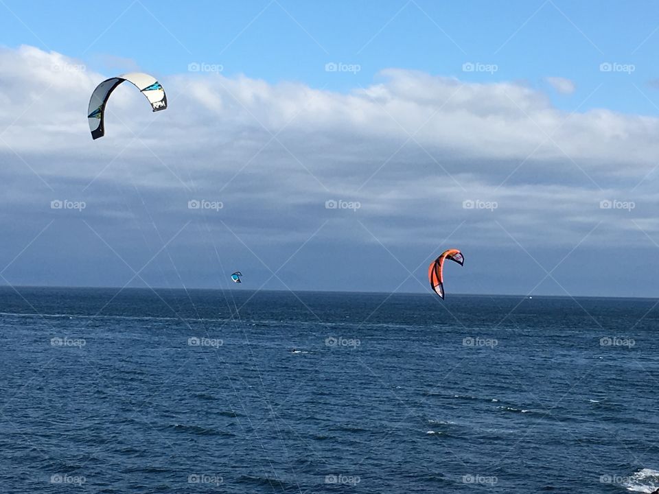 Kitesurfers surfing on sea