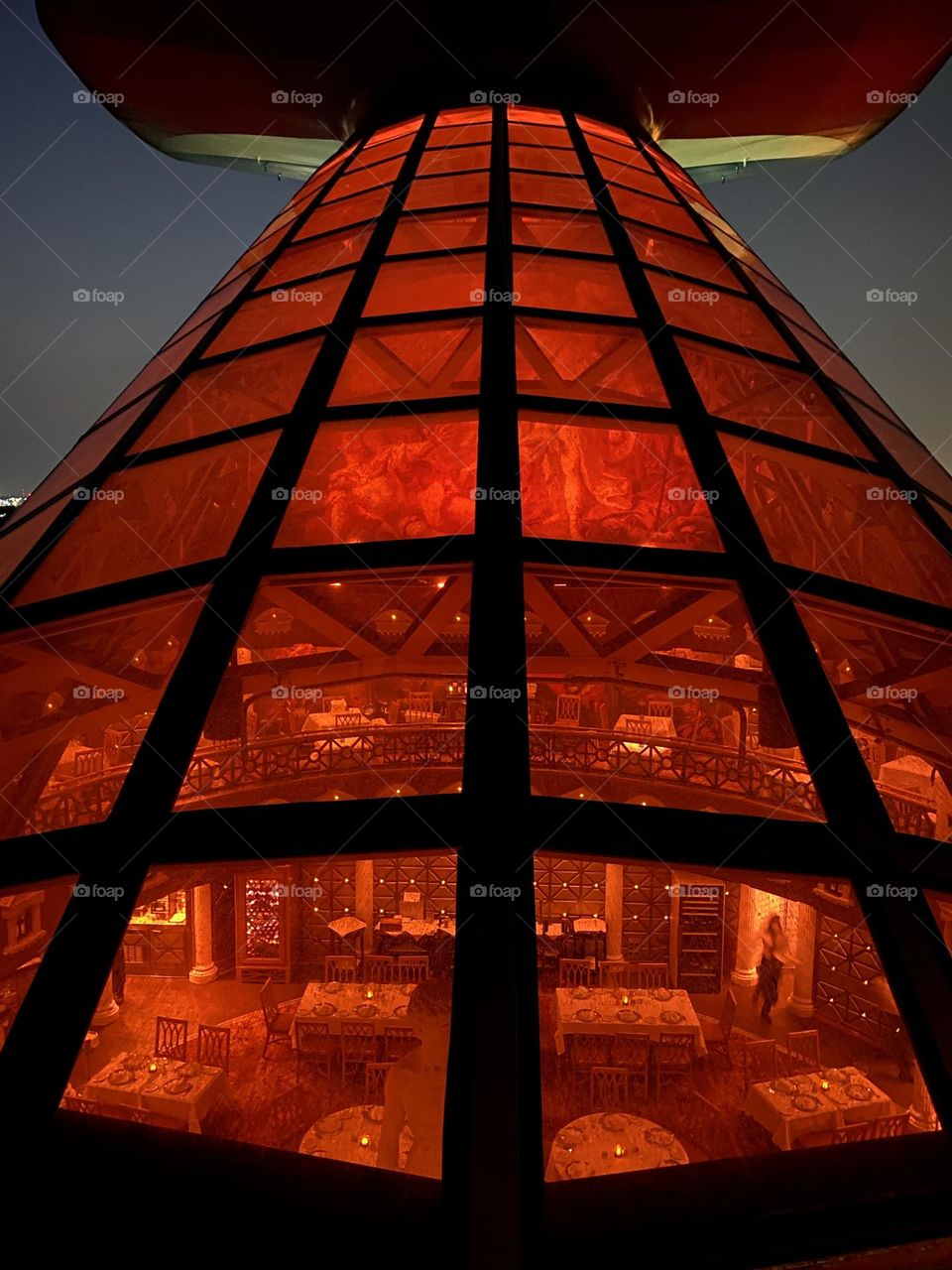 The illuminated tail fin of a cruise ship at night