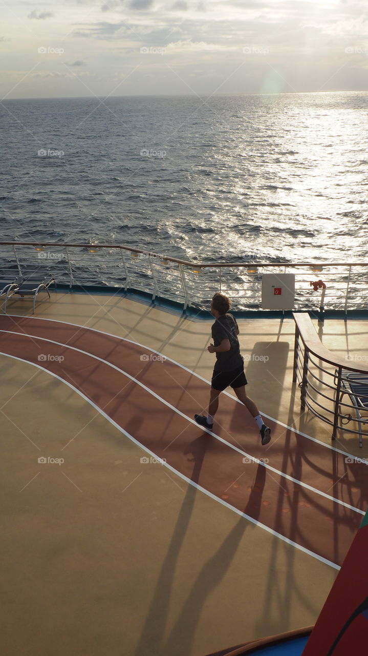 Sunset sea runner. Runner at deck on a sunset at sea