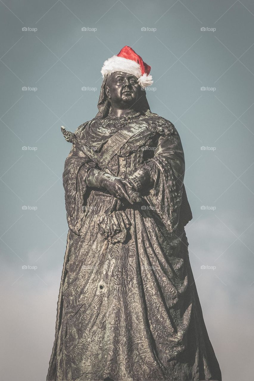 A statue of Queen Victoria wearing a Santa hat