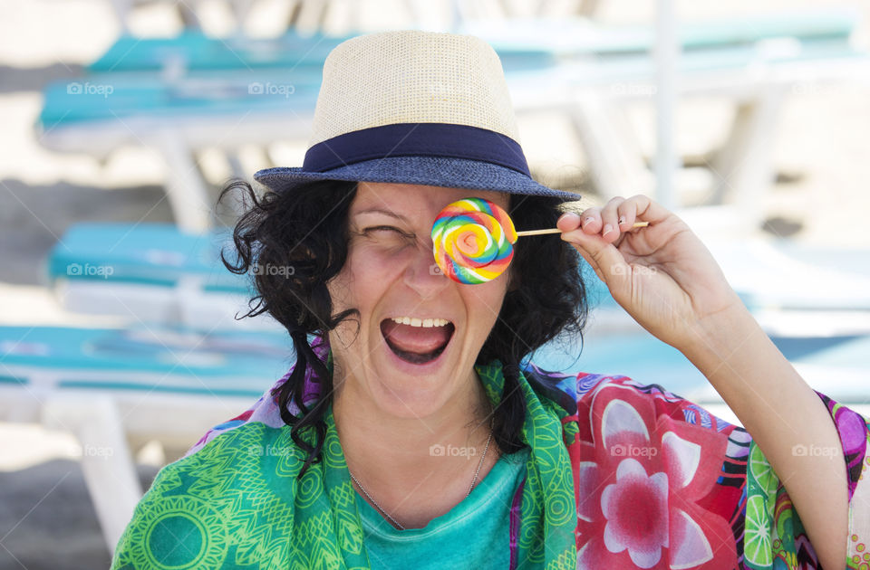 Summer colorful portrait of a woman holds lollipop