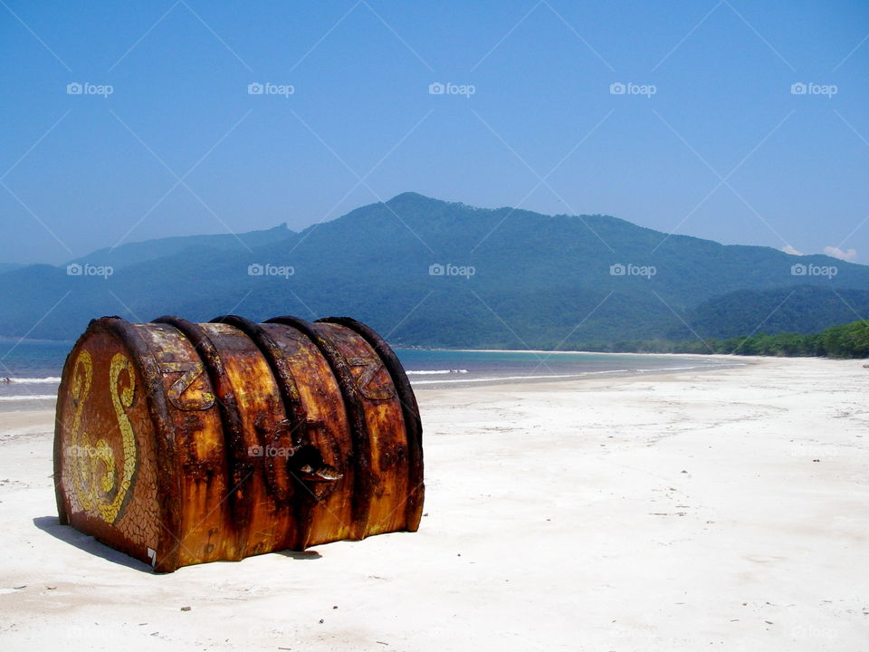 Rusty barrel on white tropical beach, Ile Grande, Brazil