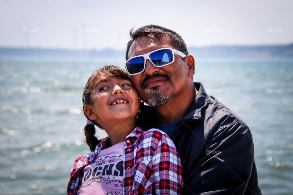 Father and his cute daughter together by the lake