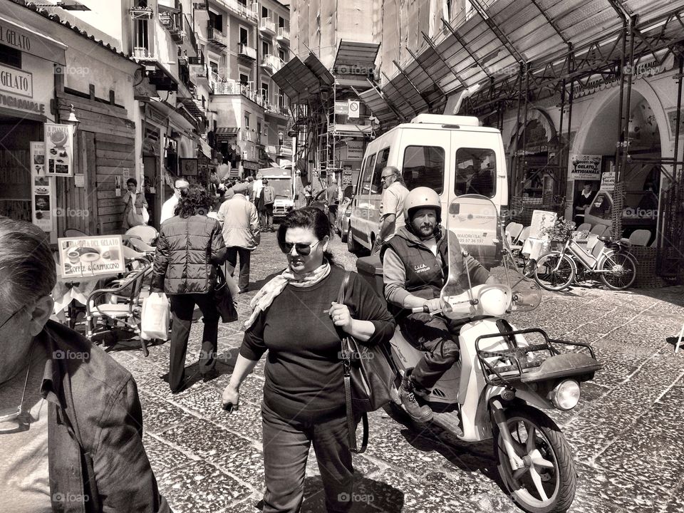 Scooter Life. Scooter rider and pedestrians in Amalfi, Italy