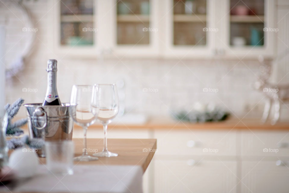 Festive winter cozy kitchen interior with garlands, decorations and gifts.  Christmas dinner at the decorated table.