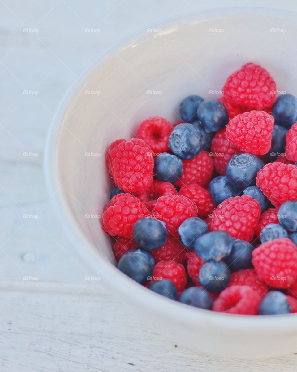 Raspberries and blueberries on table